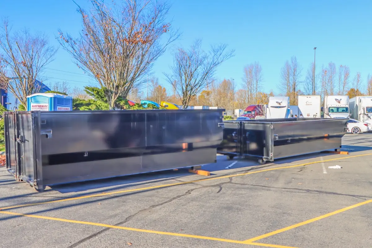 Professional dumpster rental service with roll-off container on residential driveway in Monona